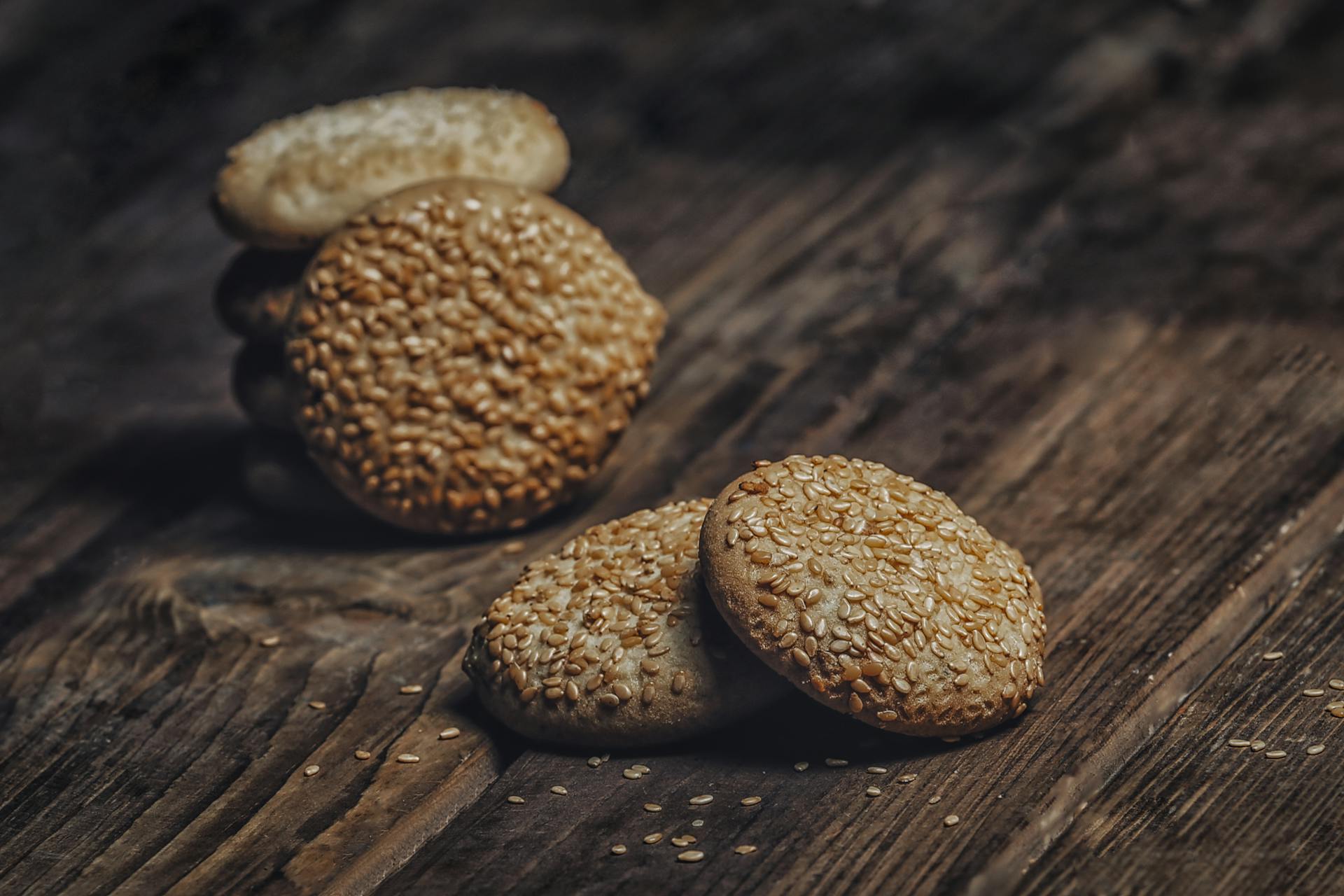 Delicious homemade sesame seed biscuits stacked on a rustic wooden surface, emphasizing texture and taste.