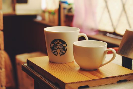 A cozy scene featuring two ceramic coffee cups on a wooden tray, perfect for a warm morning.