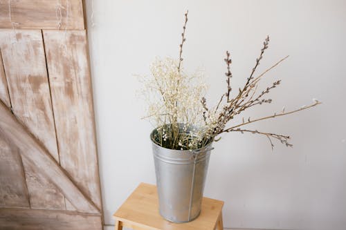 Metal Bucket with Flowers on Wooden Chair