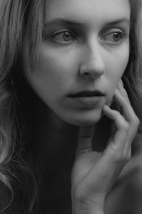 Grayscale Photo of Woman With Her Hand on Her Cheek