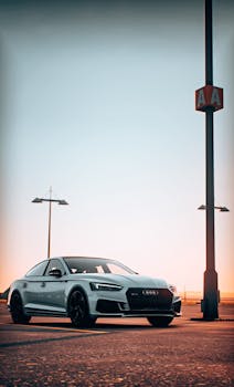 A sleek white Audi sedan parked in an outdoor lot during sunset, showcasing luxury design.
