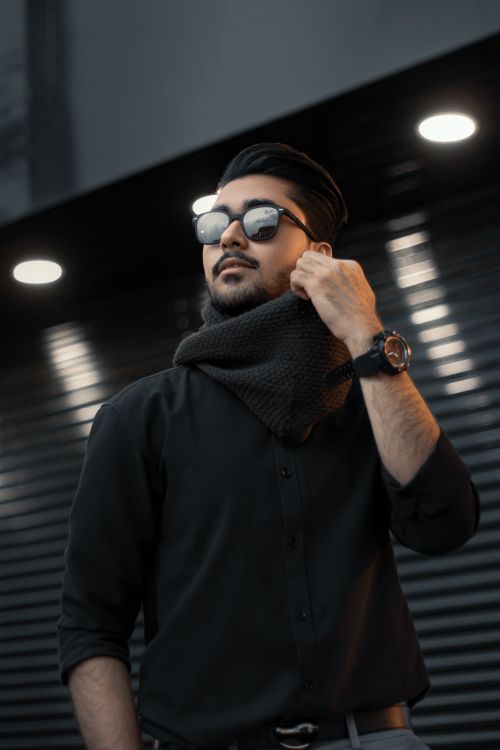 Free Fashionable man wearing sunglasses and scarf outdoors in London at night. Stock Photo