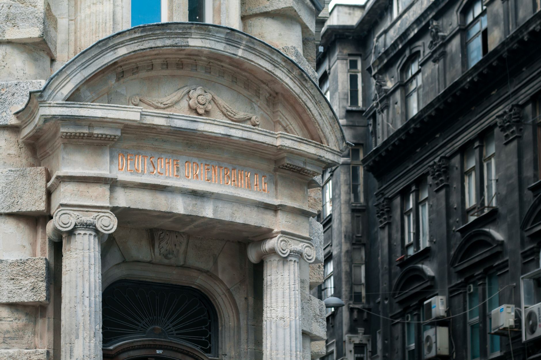 Deutsche orient bank in historical building with engraved elements and concrete columns on street near residential house in city of Istanbul