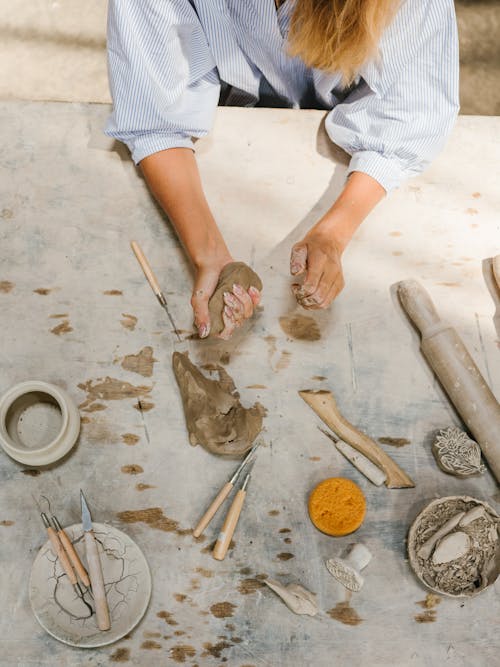Person at the Working Table Holding Piece of Pottery Clay