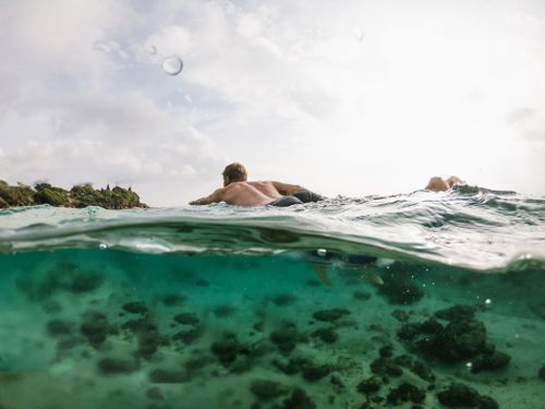 Free A man swimming in clear coastal waters, capturing the beauty of an outdoor aquatic adventure. Stock Photo