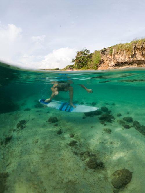 Free An underwater shot capturing a surfer holding a surfboard, showcasing a unique perspective of ocean adventure. Stock Photo