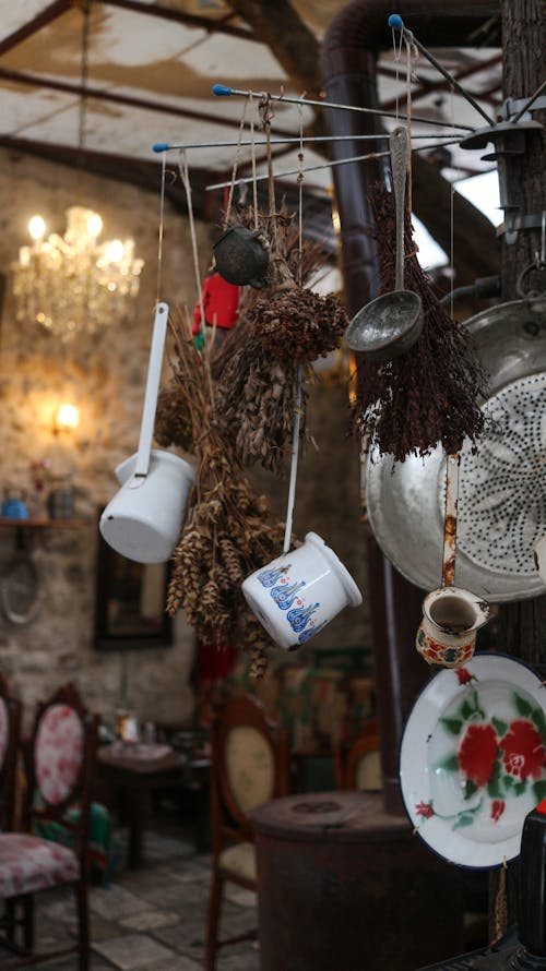 Retro kitchenware with ornament hanging between dried herbs at home