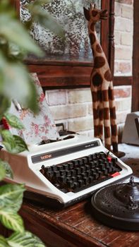 A retro typewriter set on a rustic wooden table with decorative elements, evoking nostalgia.