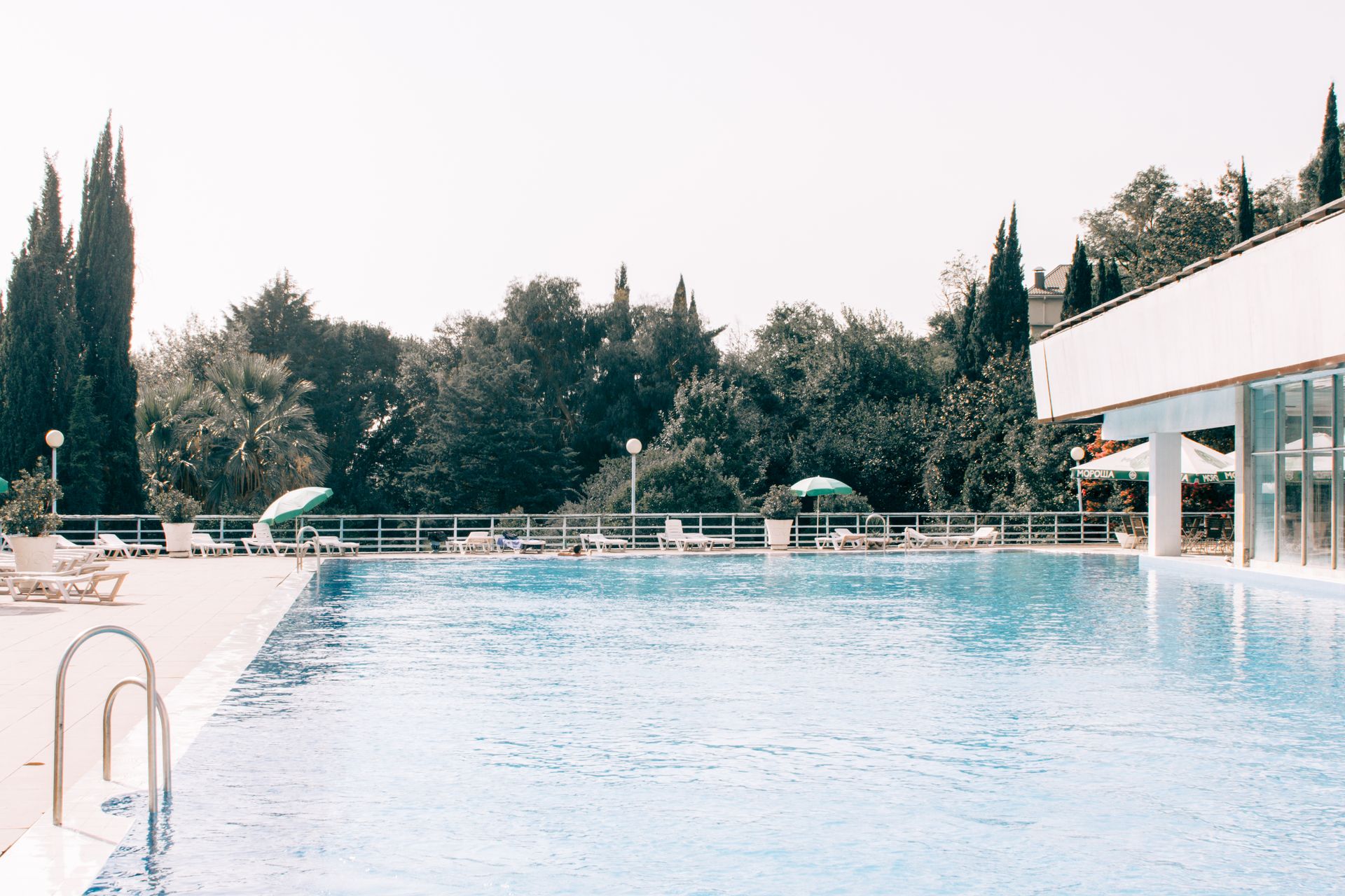 Charming outdoor pool area with clear water, ideal for relaxation and holiday vibes under summer sunlight.
