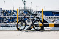 一辆自行车停在游艇码头，背景是游艇和几何形状的障碍物