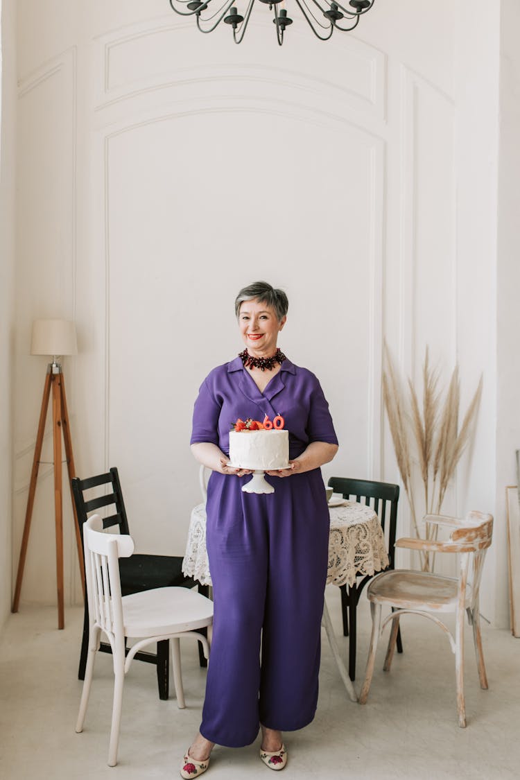 Woman In Purple Clothing Holding A Cake