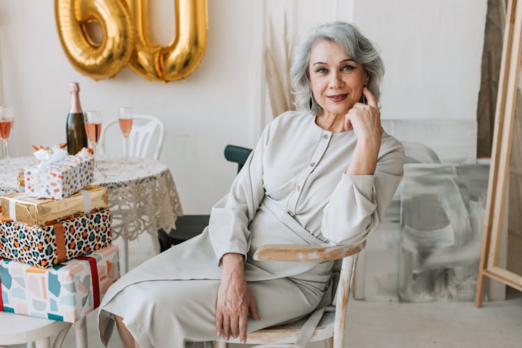 Elderly Woman Sitting On Wooden Chair