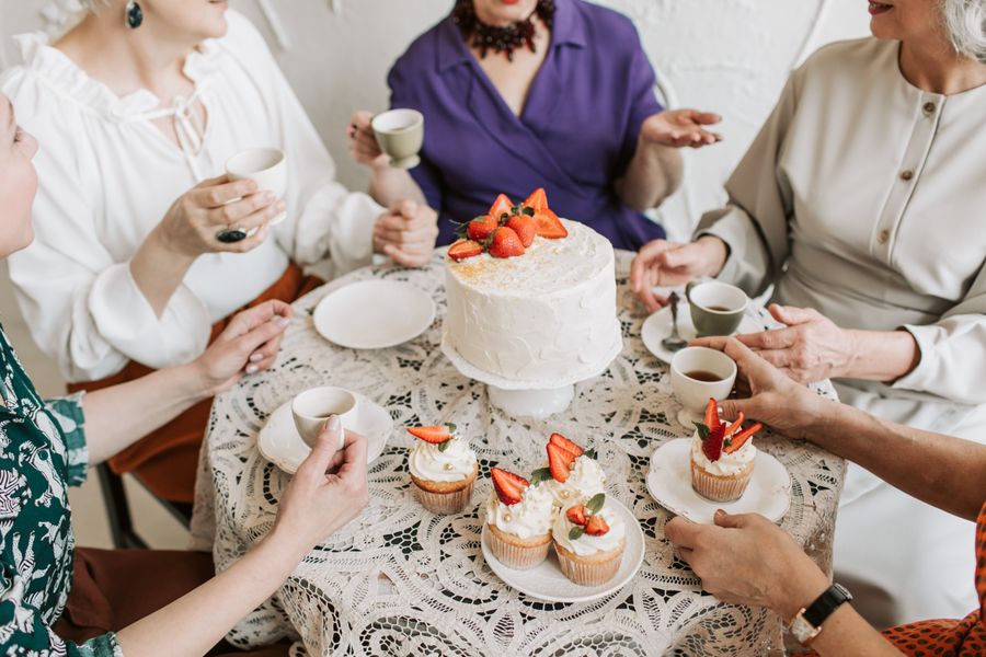 A group sharing cake and tea around a table — photo by Vlada Karpovich on Pexels