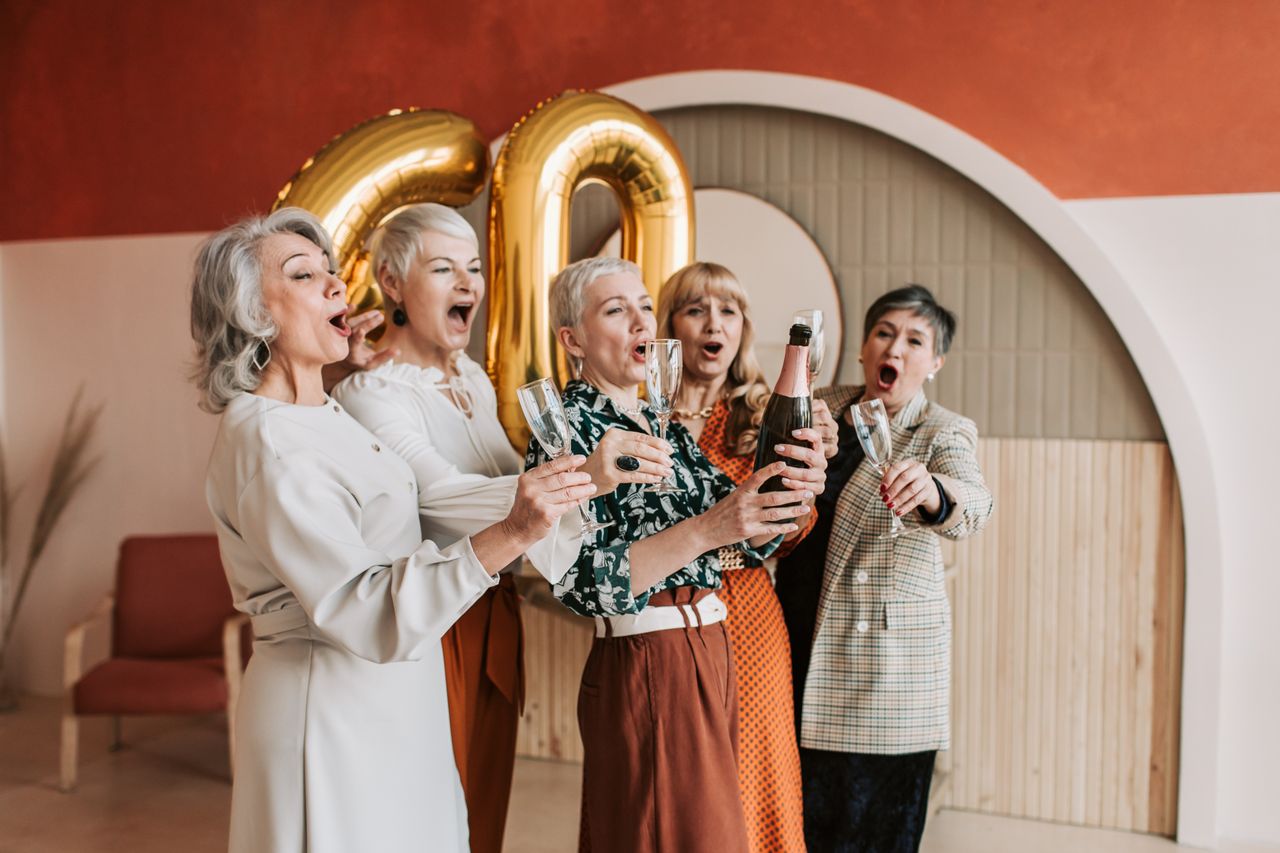 joyful senior women celebrating a 60th birthday with champagne