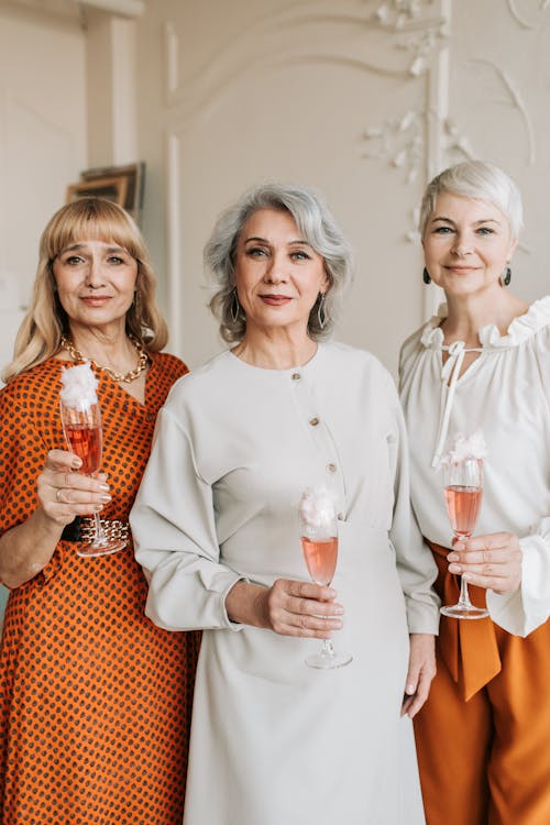 Women Holding Wine Glasses with Pink Liquid