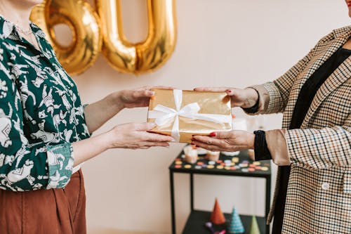 Close-up Photo of Two People holding a Present 