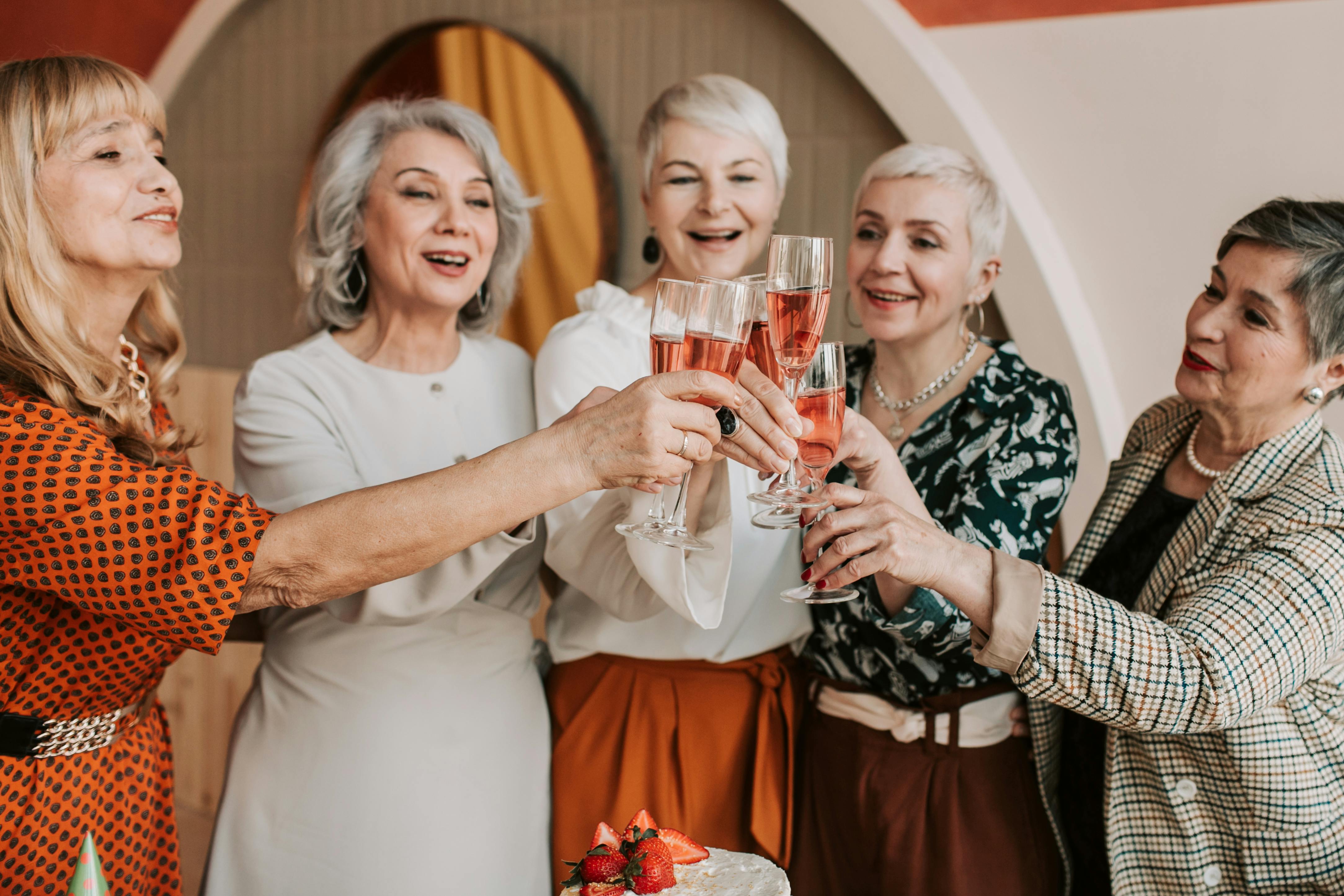 a group of elderly women clinking glasses