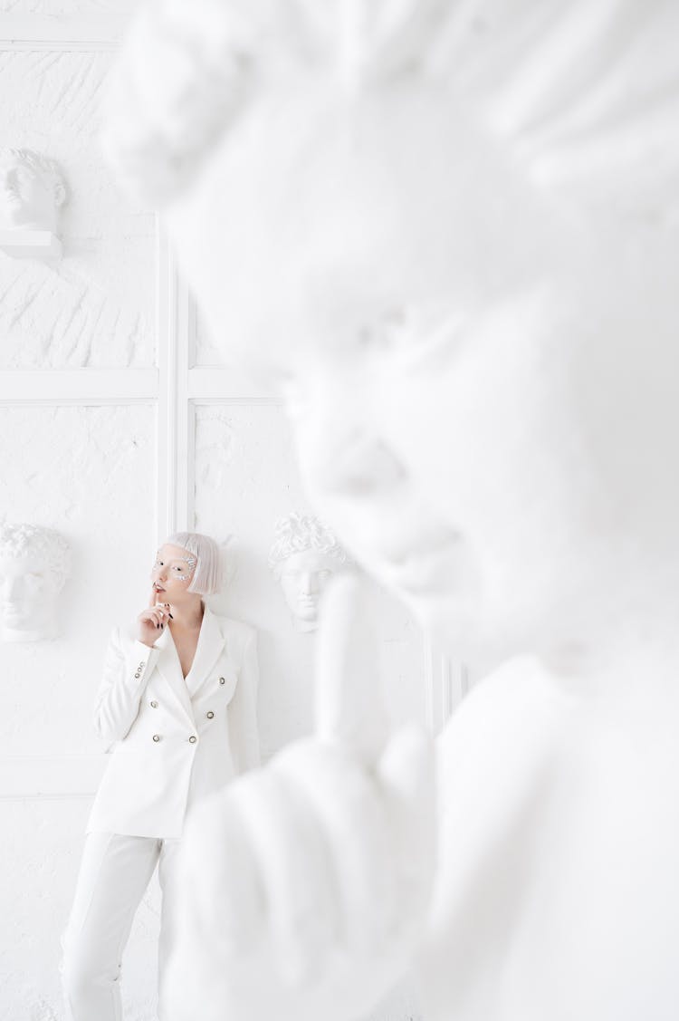 Woman Posing Among White Statues