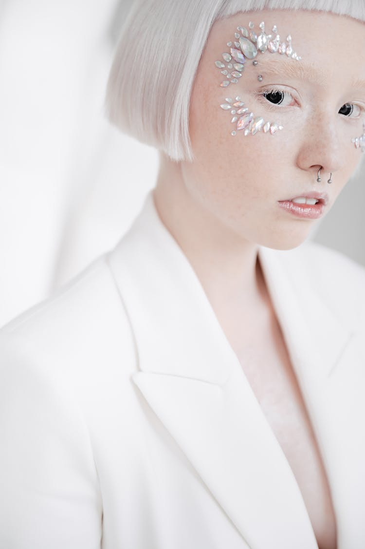 A Woman In White Blazer With Rhinestones On Face 