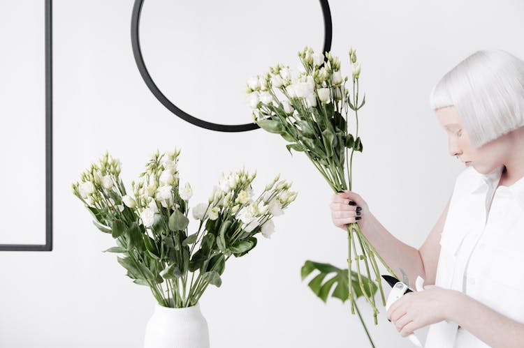 A Woman Holding A Bunch Of White Flowers