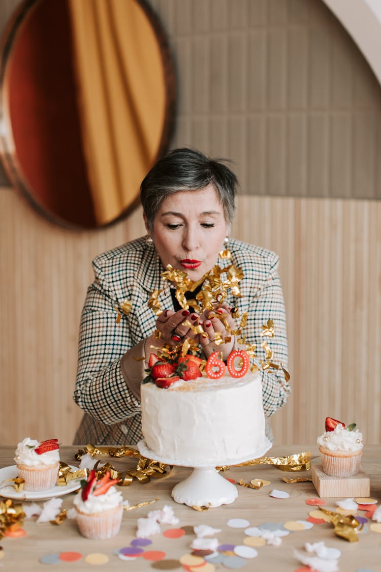 A Woman In Checkered Long Sleeves Blowing Confetti