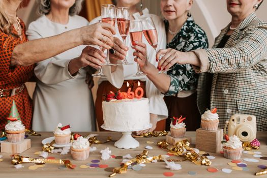 A lively 60th birthday celebration with friends toasting with champagne and enjoying cake.