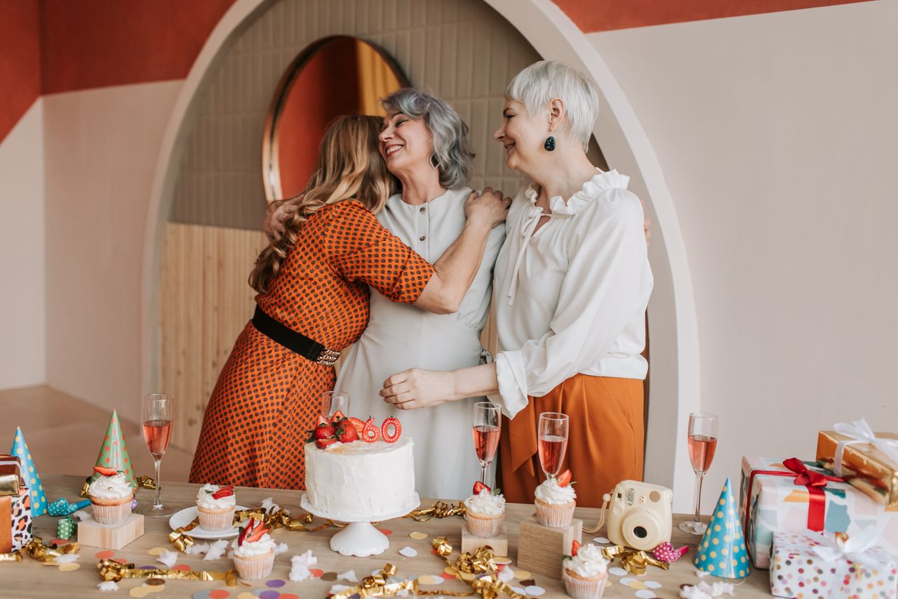 three senior women celebrating a birthday enjoying good company and ca