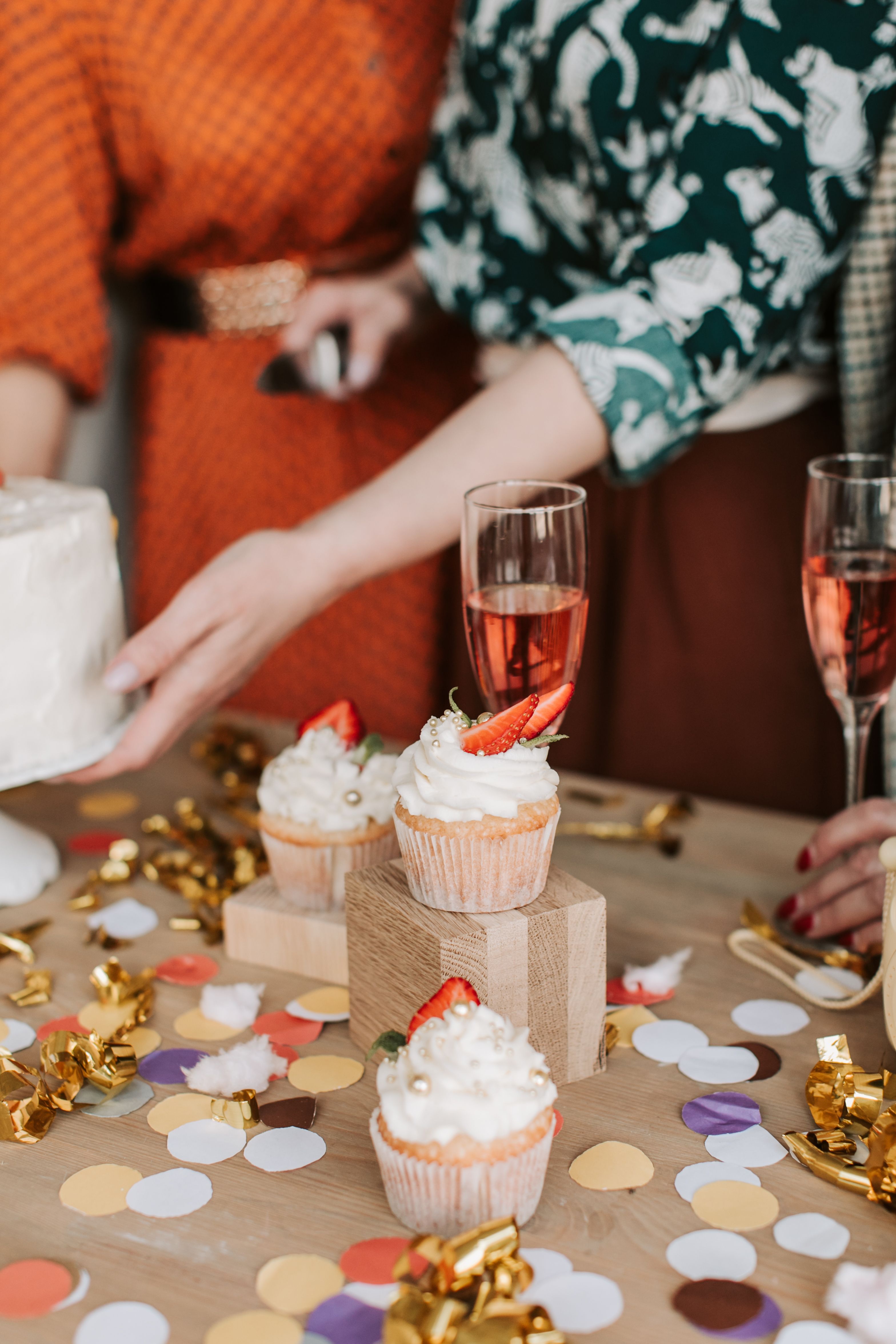 Lively party scene with cupcakes, champagne, and colorful confetti.