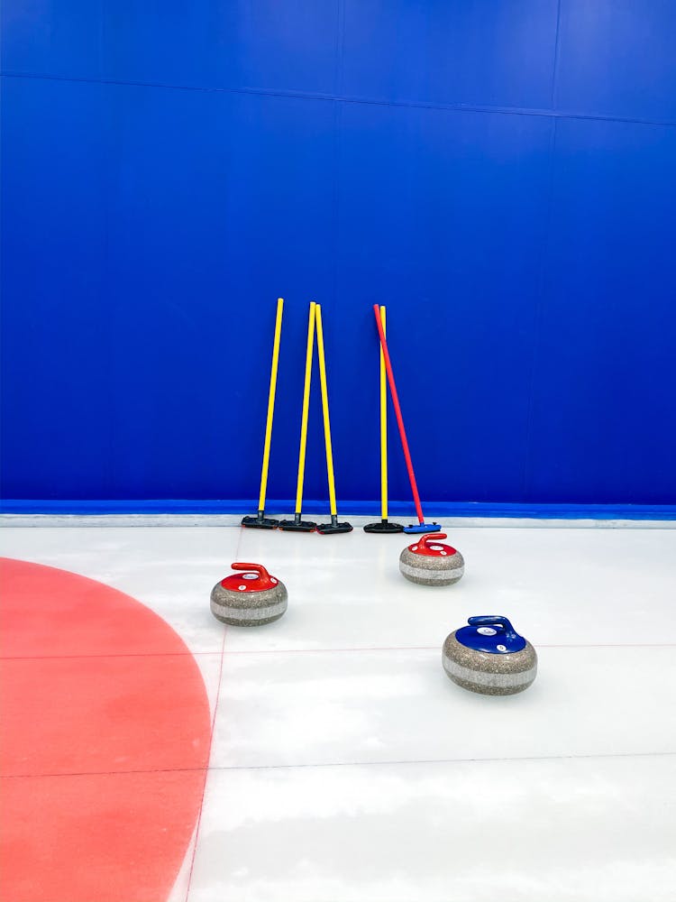 Curling Delivery Sticks And Stones Near Blue Wall 