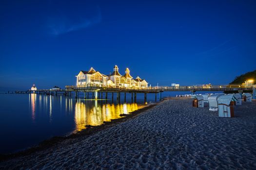 Sellin Pier beautifully illuminated at twilight, reflecting over the Baltic Sea in Germany.