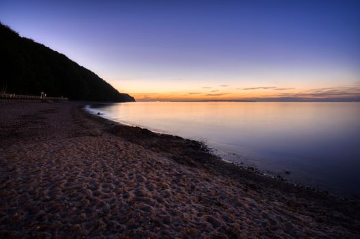Peaceful sunset over Sellin beach with calm sea and clear sky.