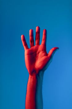 A striking image of a raised hand against a vivid blue and red backdrop, perfect for creative and conceptual themes.