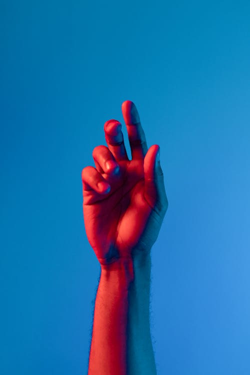 Darmowe zdjęcie z galerii z niebieski i czerwony, pionowy strzał, ręka