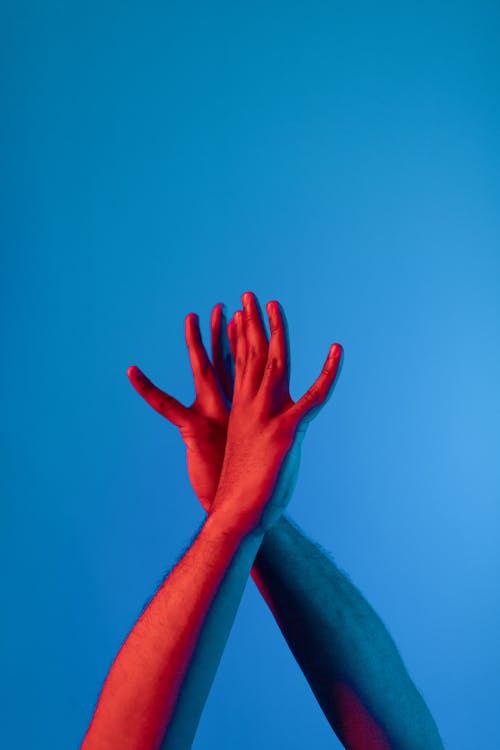 Photo of a Person's Hands with a Blue Background