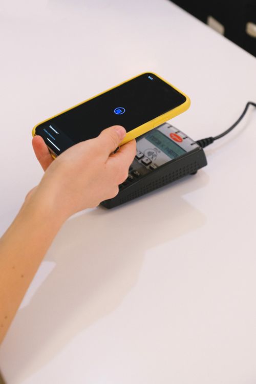 Osoba koristi smartphone za beskontaktno plaćanje na terminalu