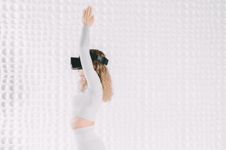 Woman With Arms Raised And VR Goggles