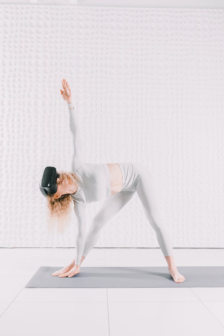 Woman Practicing Yoga With VR Goggles