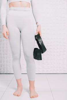 Woman holding a VR headset in a bright, minimalist indoor space. Perfect for technology and lifestyle themes.