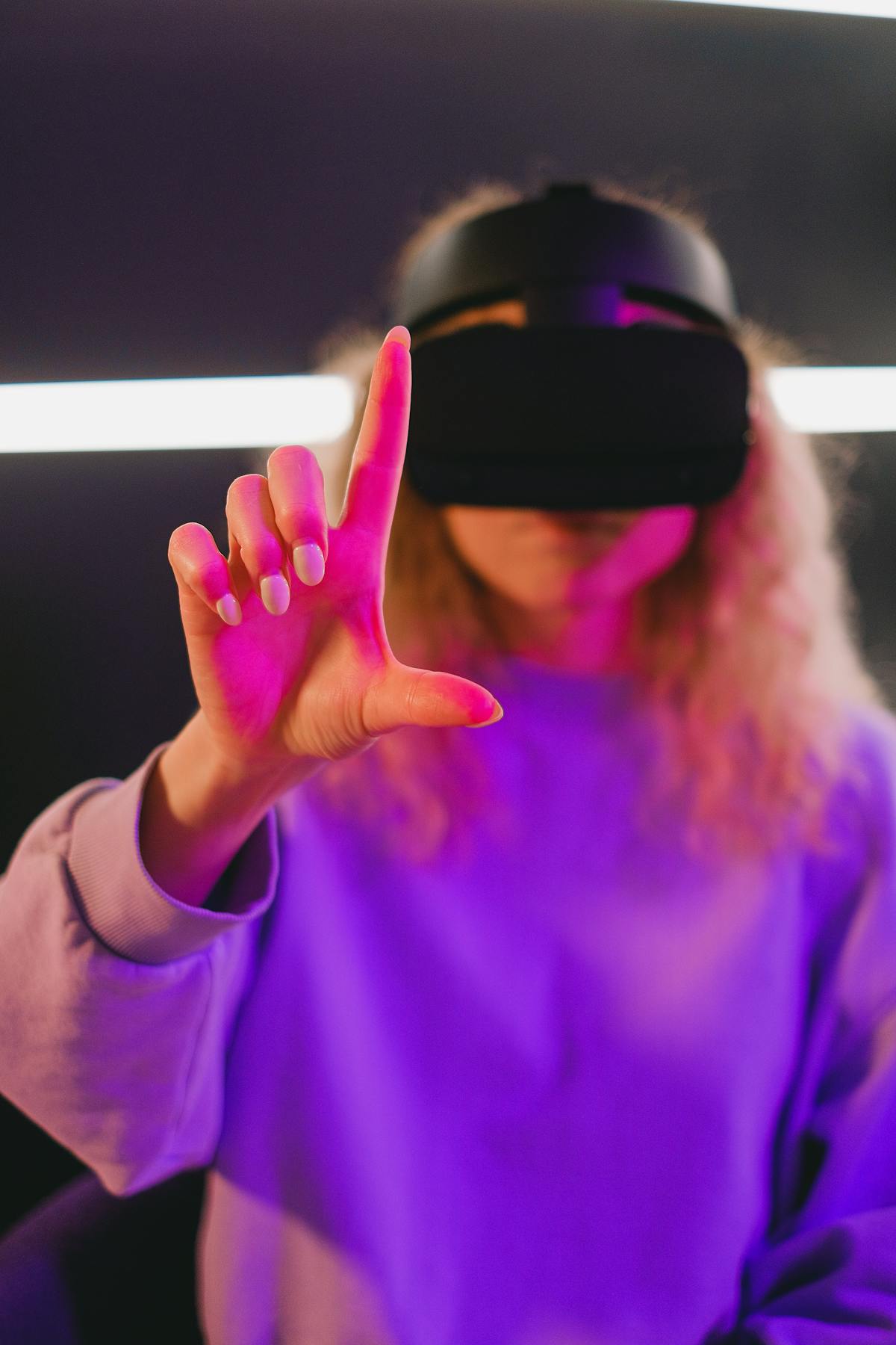 Primo piano di una persona con visore VR che allunga la mano