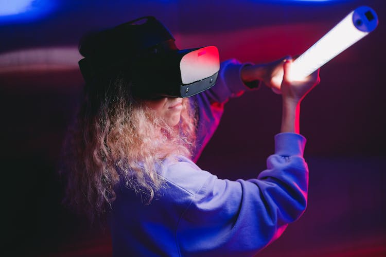 Woman Playing On A Game With VR Headset And Holding A Light Sword