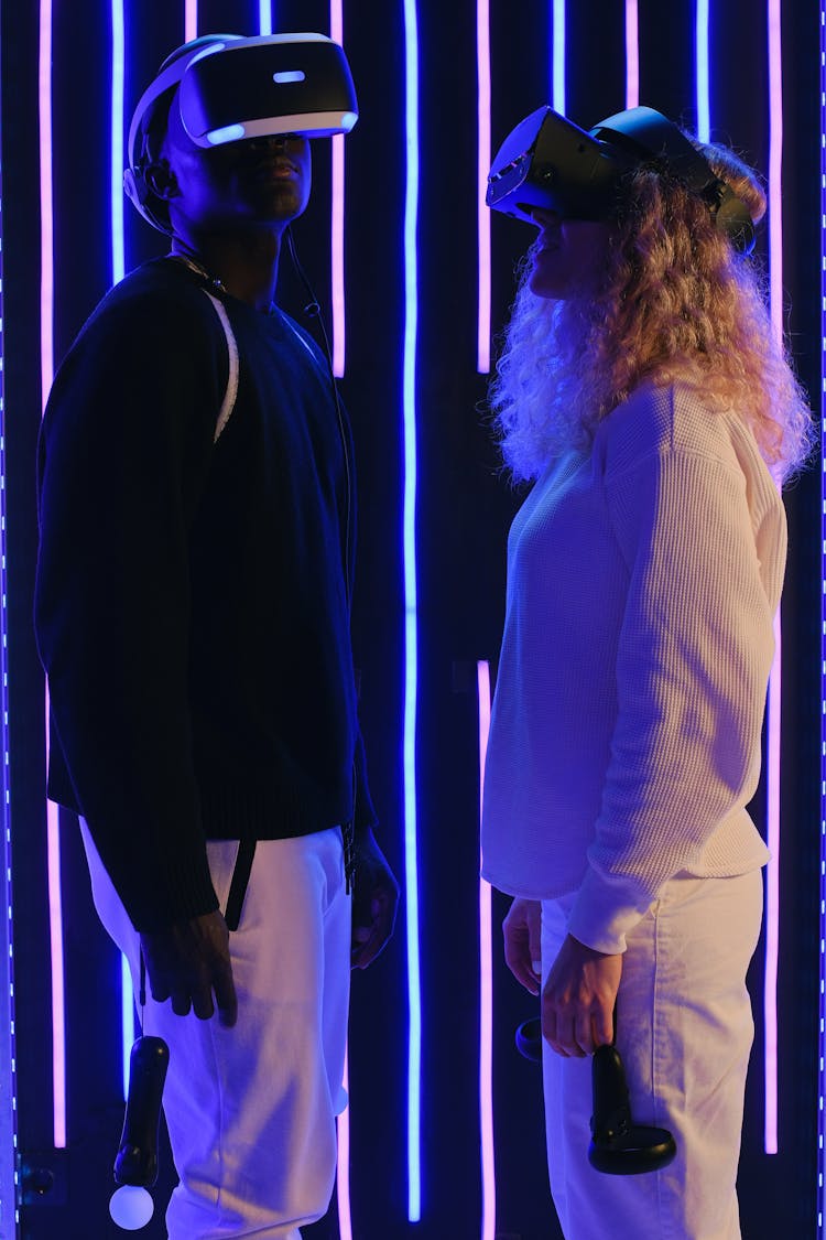 Couple In VR Glasses In Dark Illuminated Room