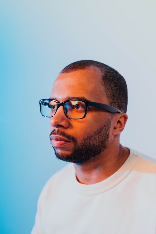 Free Close-up portrait of a man wearing glasses with studio lighting highlighting facial features. Stock Photo