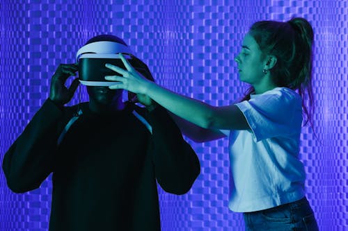 Girl Helping a Man with Putting on a VR Headset