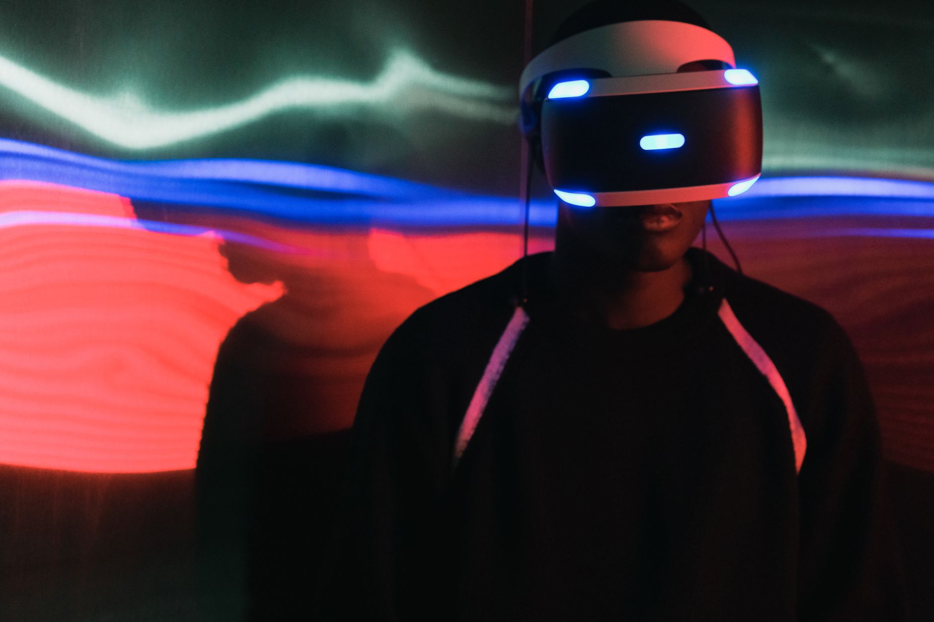 Person wearing a virtual reality headset with vibrant light trails in the background.