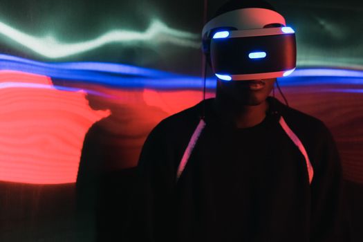 Person wearing a virtual reality headset with vibrant light trails in the background.