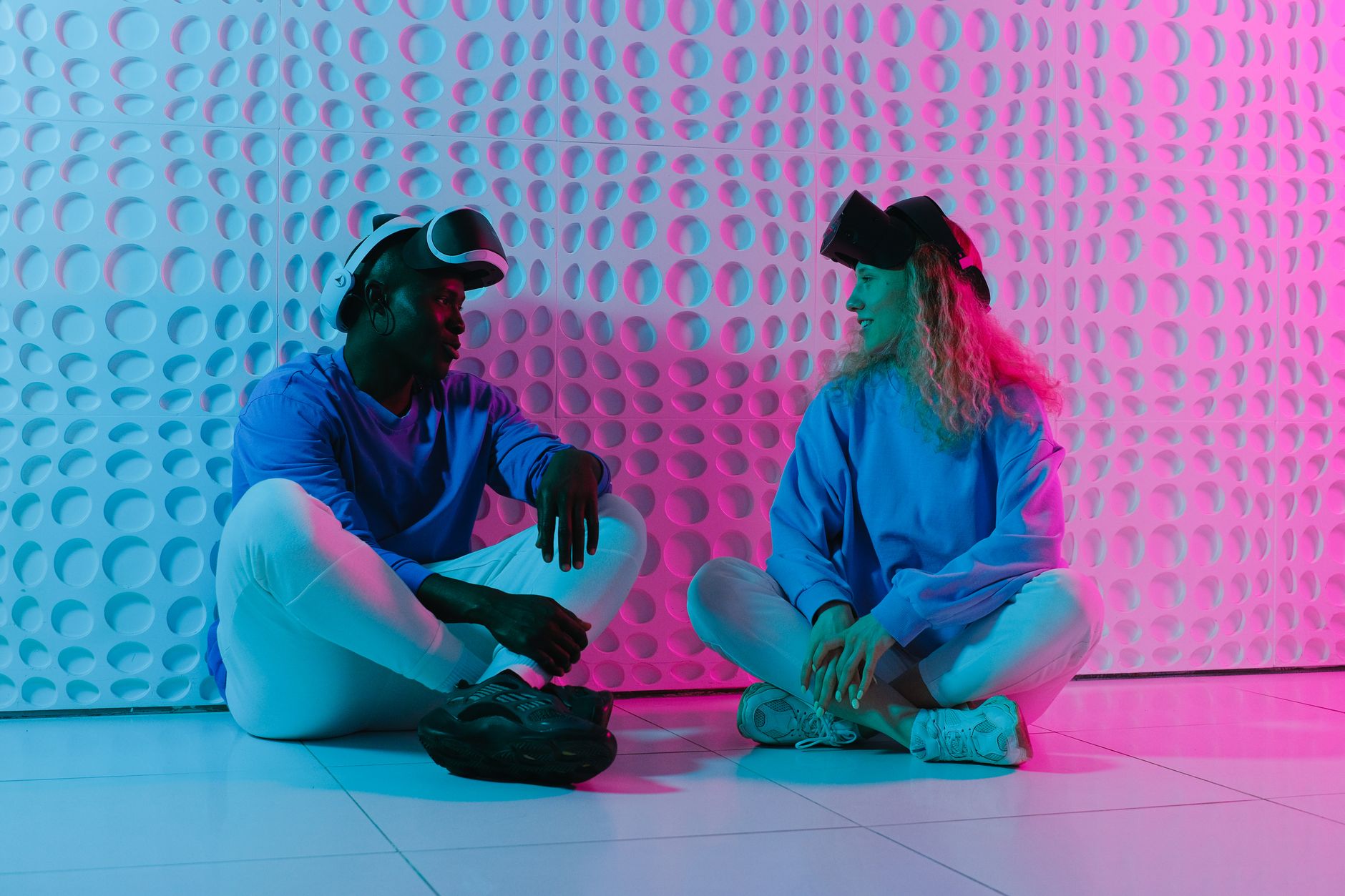 Two people engage with VR headsets in a futuristic, colorful environment.