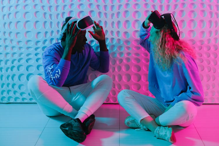 Woman And Man Sitting With VR Goggles