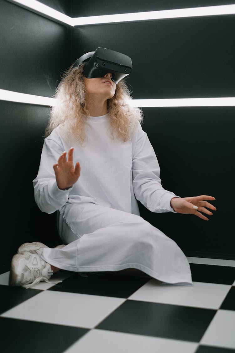 A Woman Wearing A Virtual Reality Headset And Sitting On The Floor