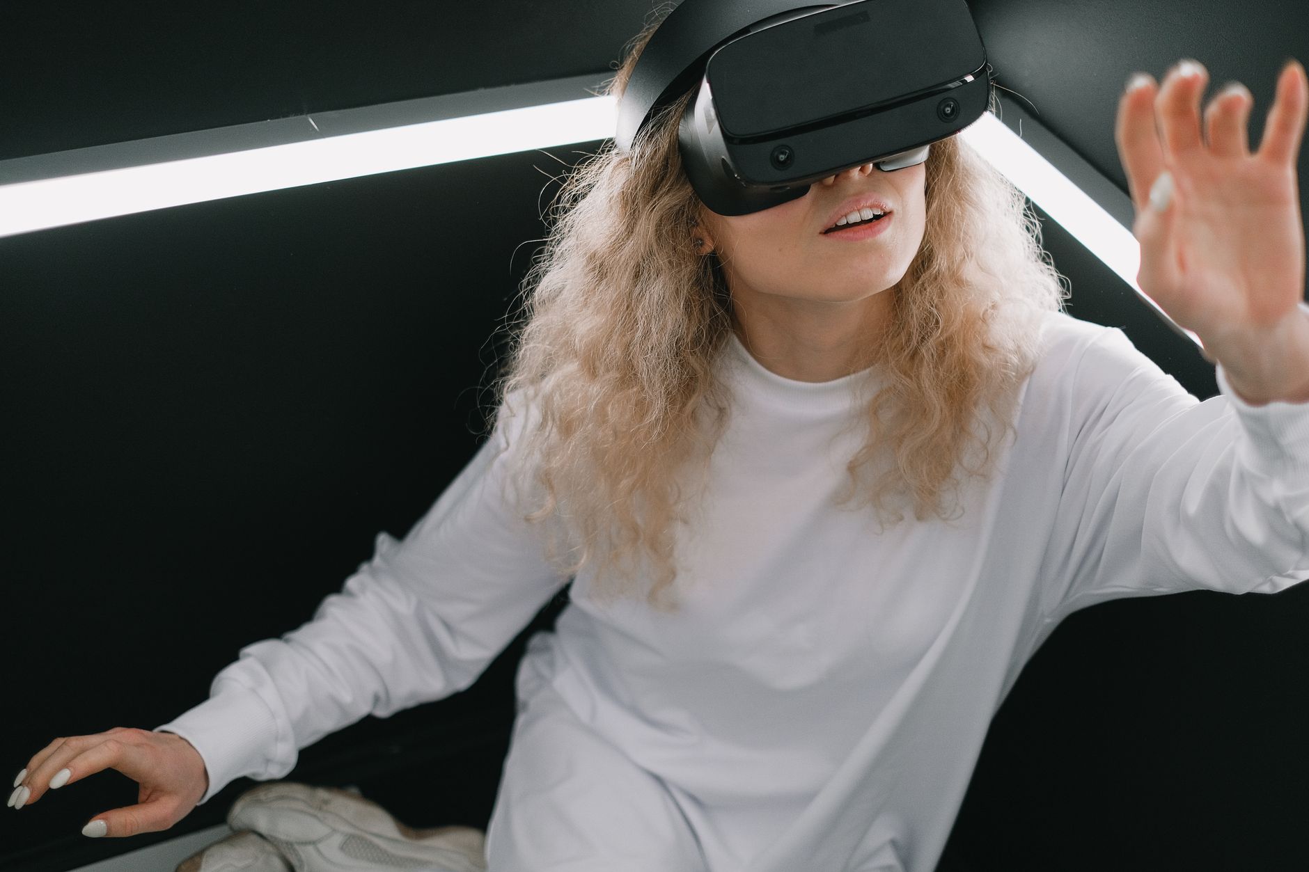 A woman exploring the virtual reality metaverse with a VR headset indoors.
