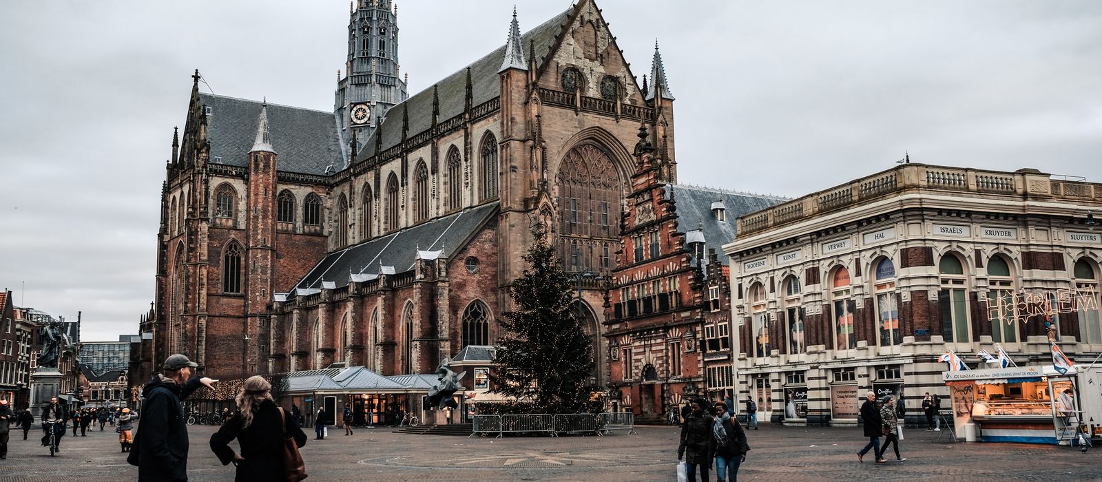 Scenic view of a historic church and lively square in Haarlem, Netherlands.